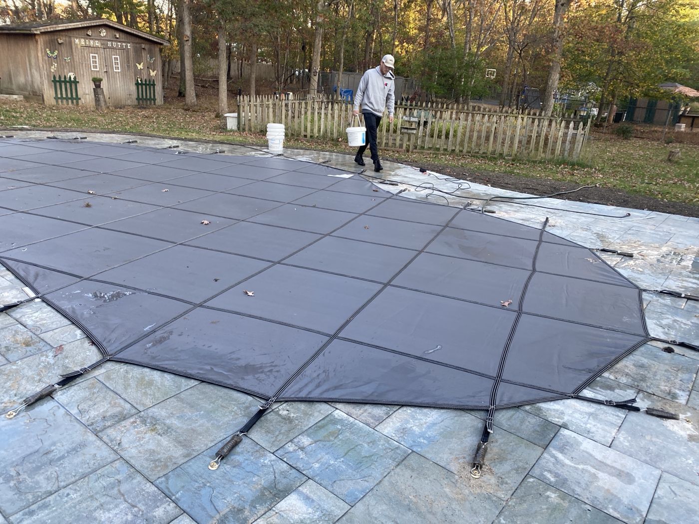 A tech fitting a safety cover at a pool closing