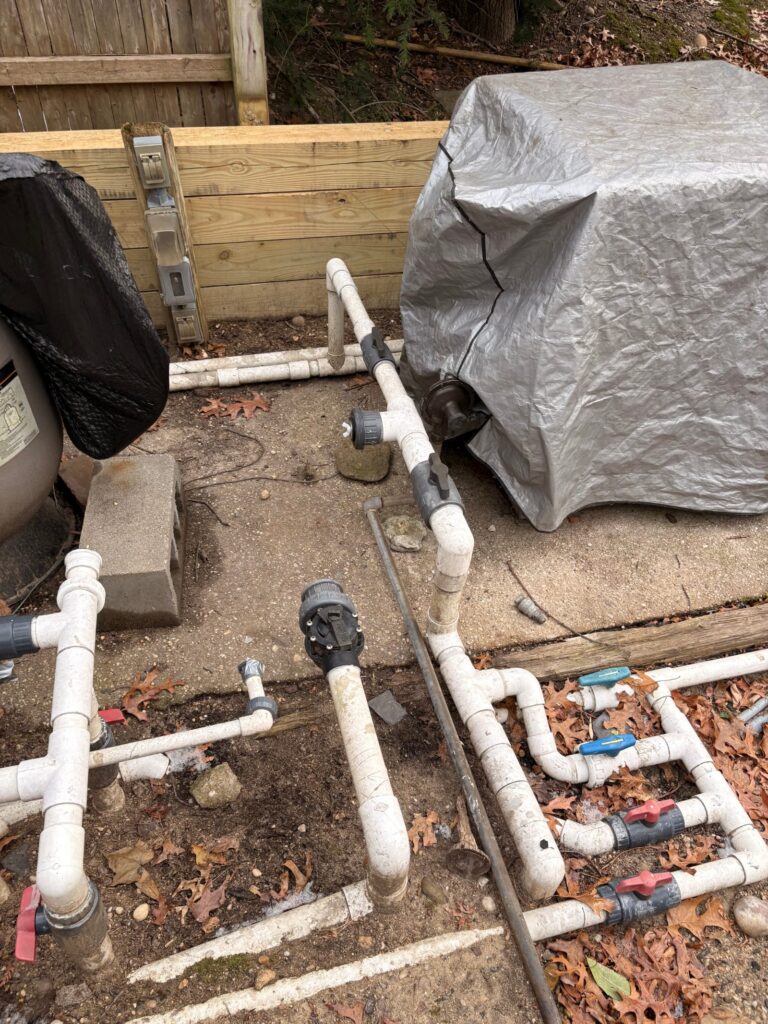 Pool heater and filter wrapped in tarps on a Long Island equipment pad in winter
