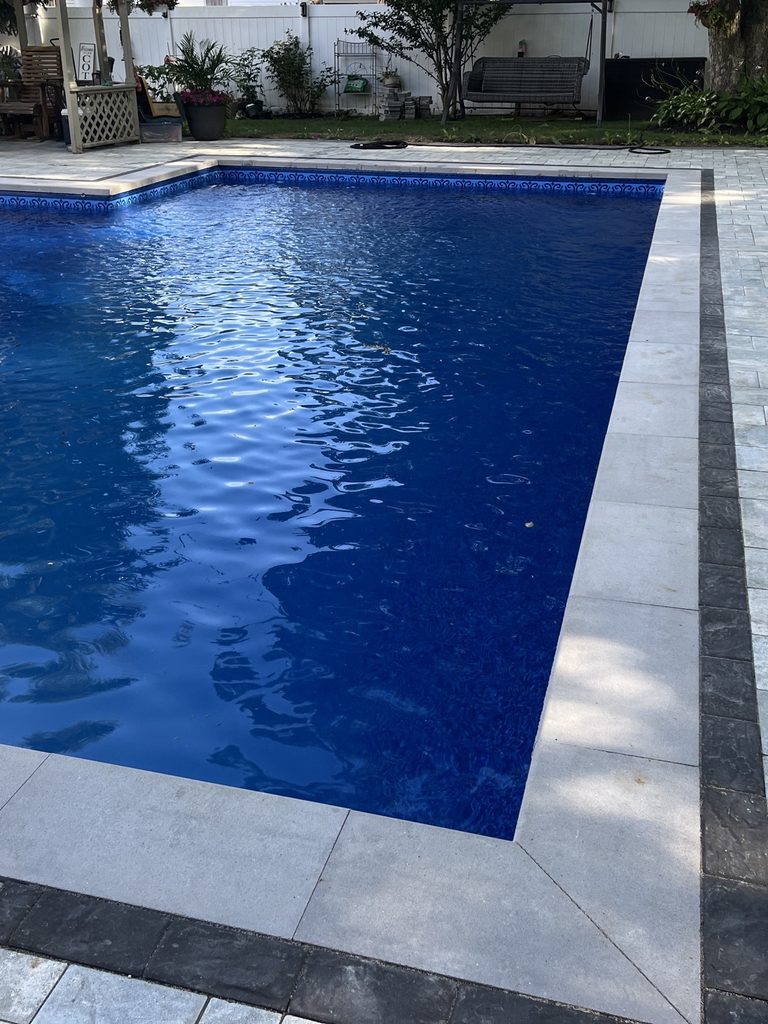 After: the same pool renovated with a new blue liner and coping