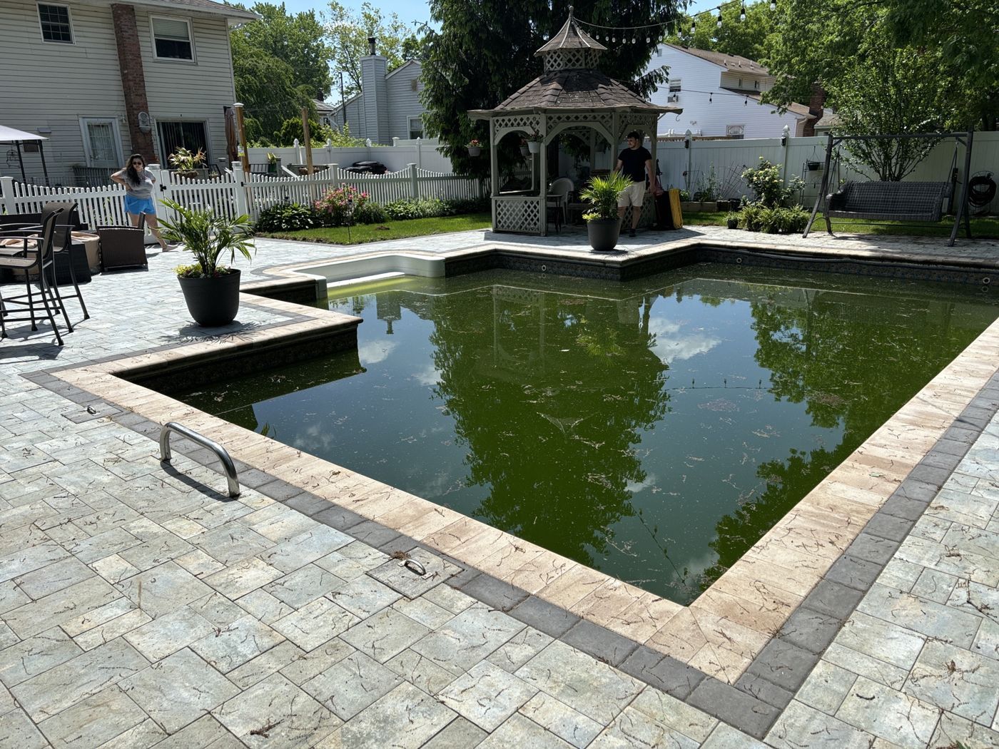 Before: a dark green pool with a gazebo behind it