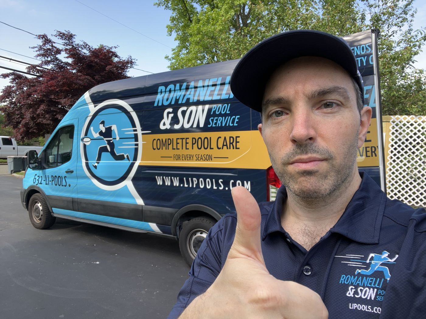 Rocco Romanelli giving a thumbs up in front of a wrapped Romanelli service van