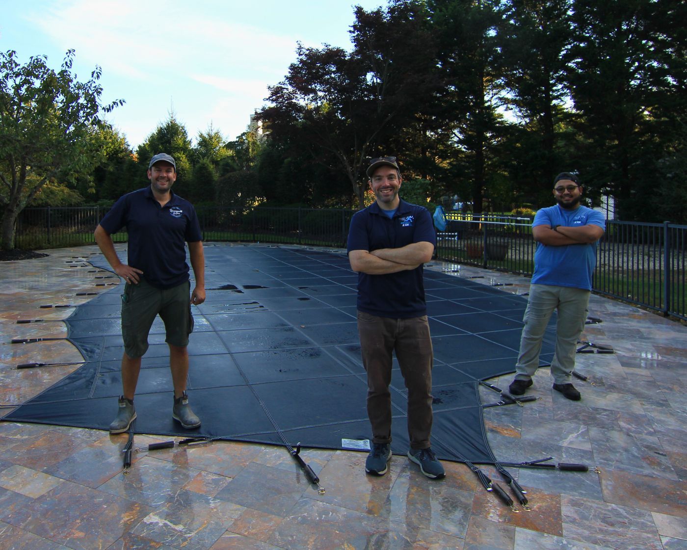 Three Romanelli installers standing on a newly fitted safety cover