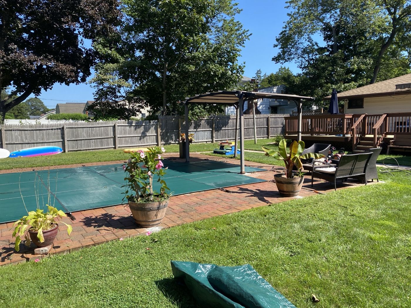 A green safety cover fitted on a backyard pool